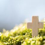 Symbole der christlichen Bestattung - Weißes Kreuz in Blumen für eine Bestattung - Bestattungen Stuttgart